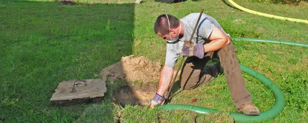 Septic pumping technician servicing a residential septic tank in Cherry Hill, NJ